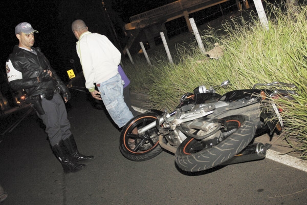Policial cabo Crisol observa motocicleta acidentada na noite de ontem na Avenida das Primaveras e que resultou na morte da gerente Nayara Rocha dos Santos, 24